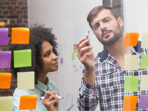 Stock photo of man and woman at glassboard