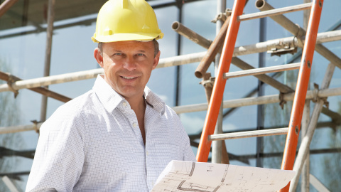 Photo of man on a building site wearing a hard hat