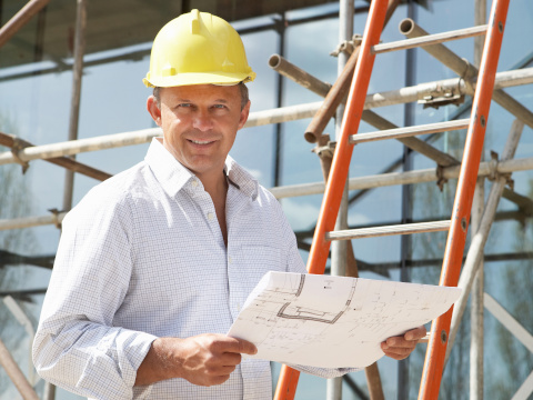 Photo of man on a building site wearing a hard hat