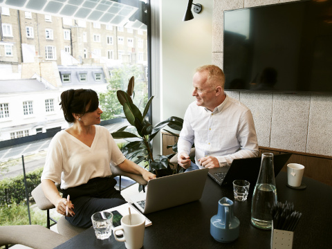 Photo of woman and man consulting in meeting room